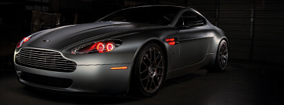 Flat grey Aston Martin with red halo headlights